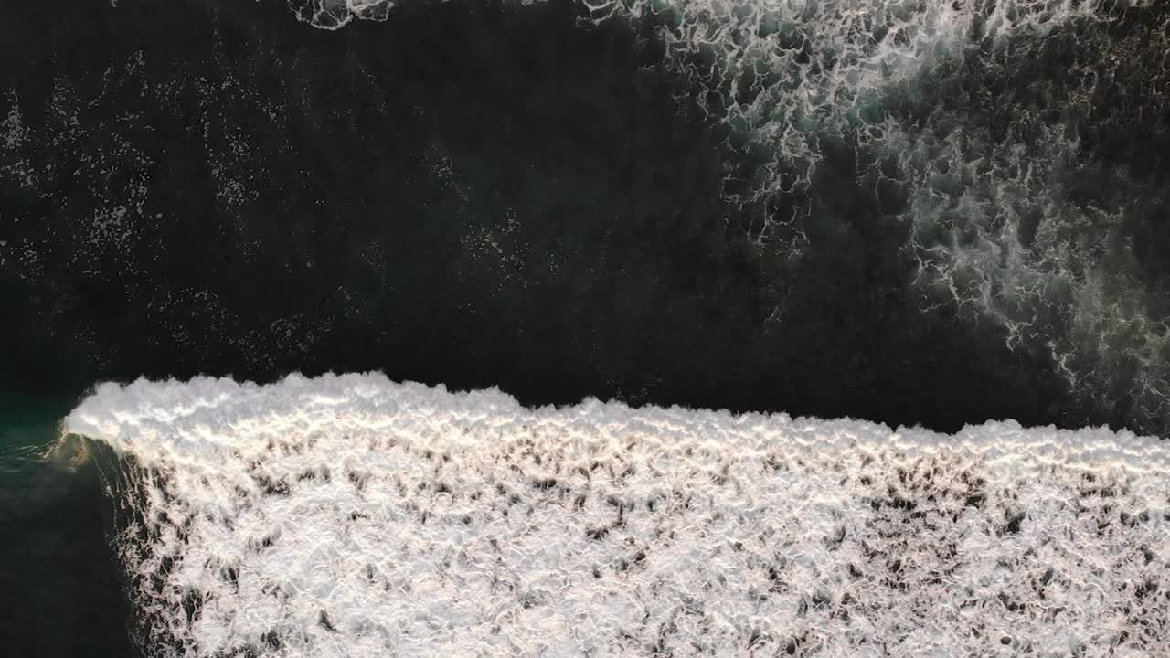 Aerial view of waves rolling through in Uluwatu, Bali