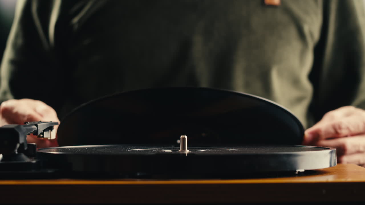 Persona che posiziona un disco in vinile sul giradischi e abbassa la puntina