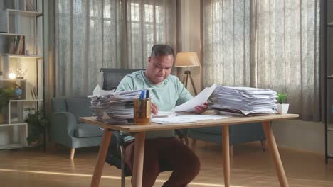 feliz hombre gordo asiático celebrando terminar de trabajar con documentos en la oficina