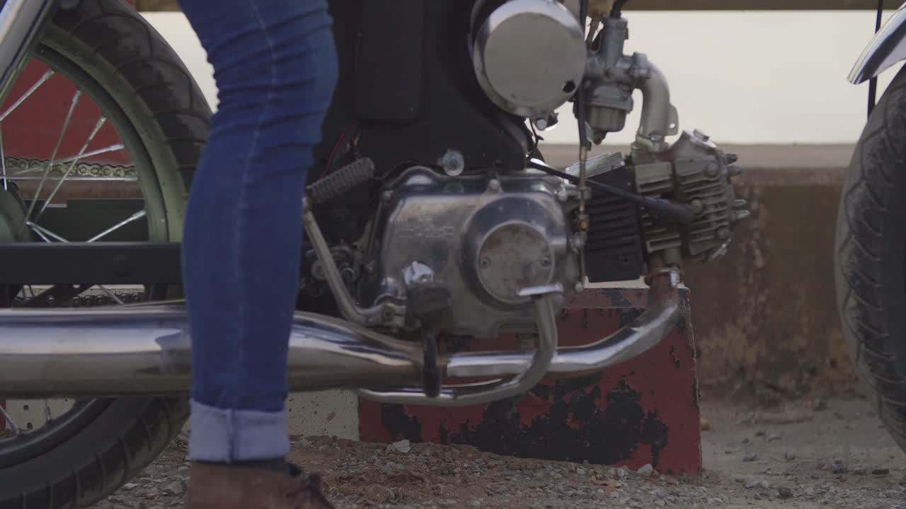 Close-up of a vintage motorcycle with rider's legs