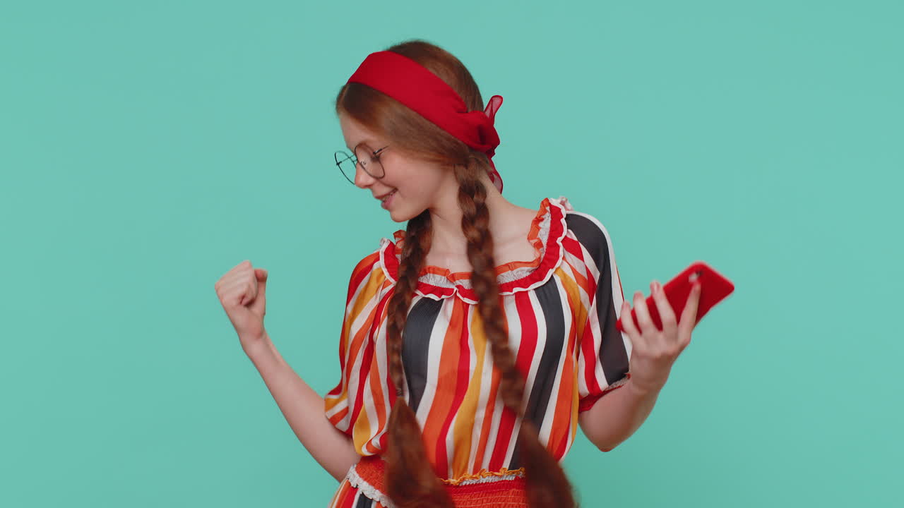 feliz emocionada chica usar teléfono móvil decir wow sí descubrió gran gran noticia ganar haciendo el gesto ganador