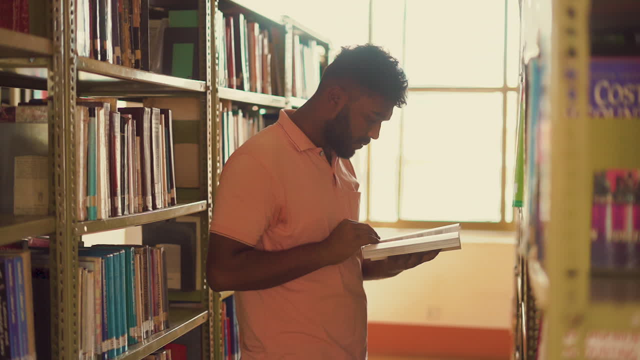 The video showcases a Nepali boy around 23, reading a book at the library of the University. His focused demeanor and the peaceful environment of the library create a serene and studious atmosphere.