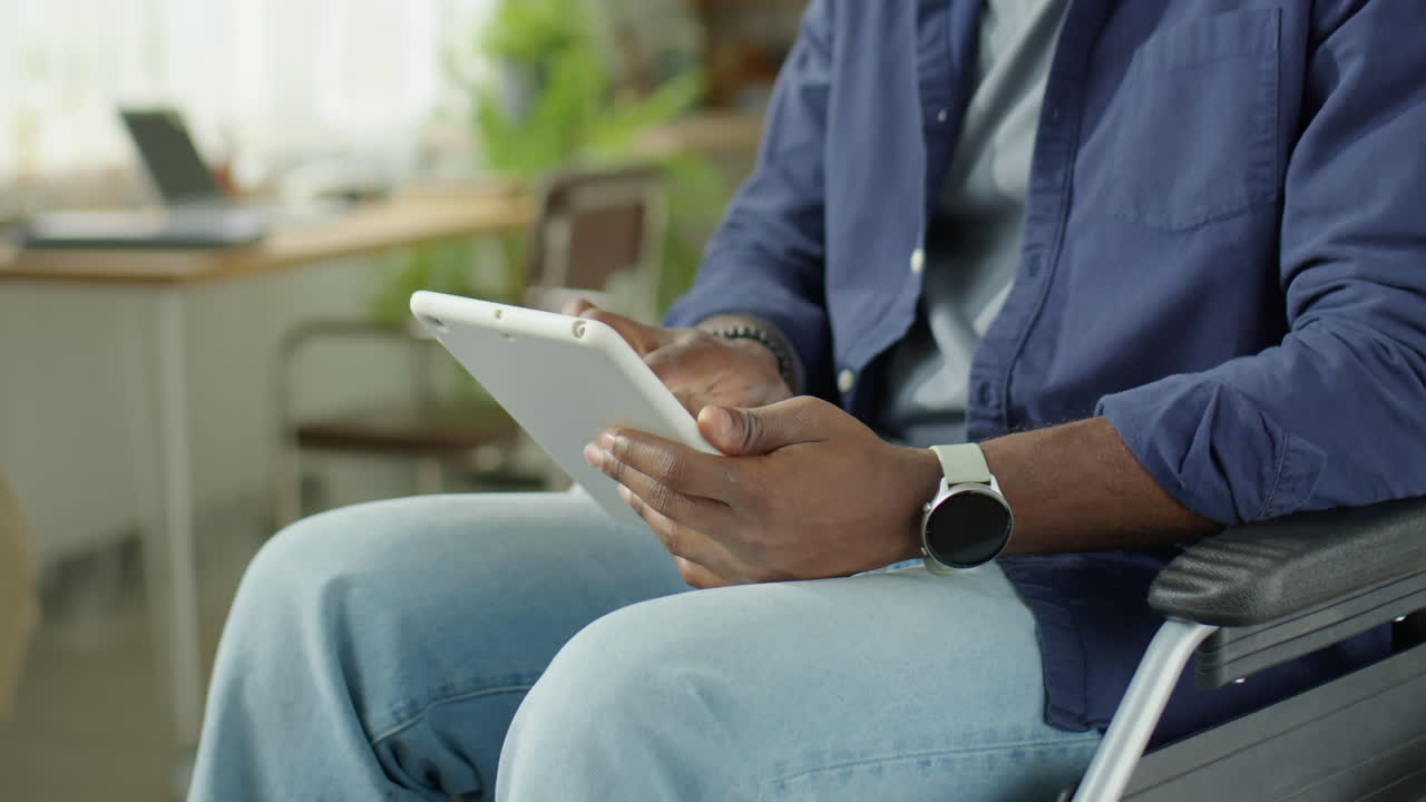 Man in Wheelchair Typing on Digital Tablet