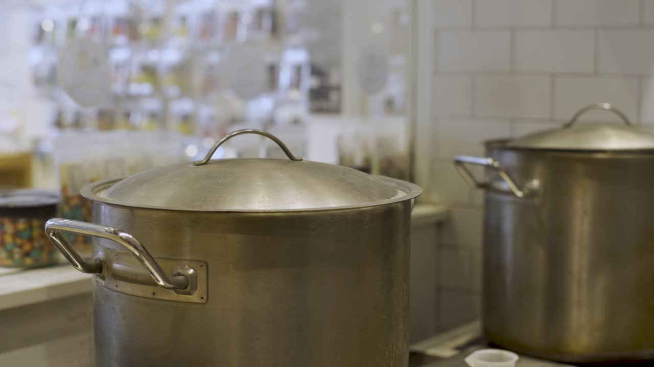 Two steaming pots cooking boiling caramel candy. Making sweets. Camera Panning