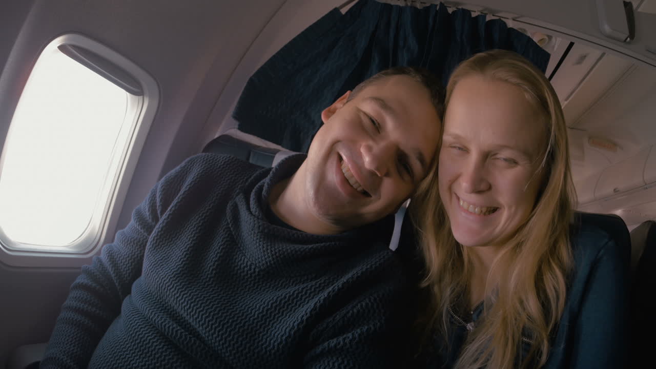 una joven pareja enamorada en el avión.