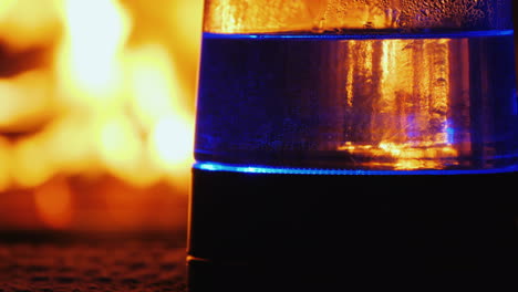 el agua hierve en un hervidor eléctrico retroiluminado un fuego en el fondo arde en el fondo