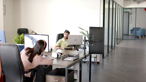 using vr headsets and computers, colleagues working on robotics project in office