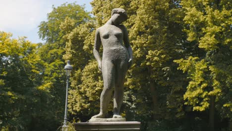 the hellenes of france- statue of a woman standing known as "purity" in parc montsouris, paris, france - low angle shot