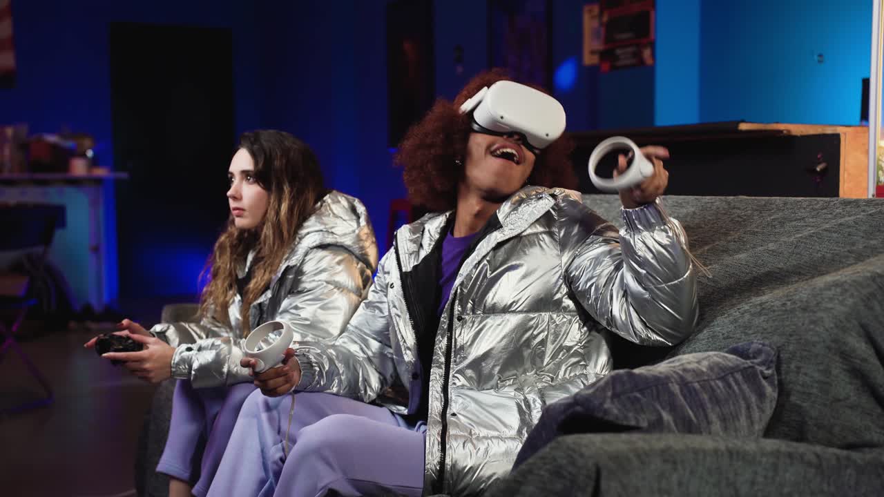 jugadores de video masculinos y femeninos en ropa futurista en el sofá