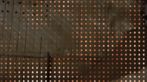 wooden planks displaying dotted light grid, featuring horizontal beam and metal bracket support