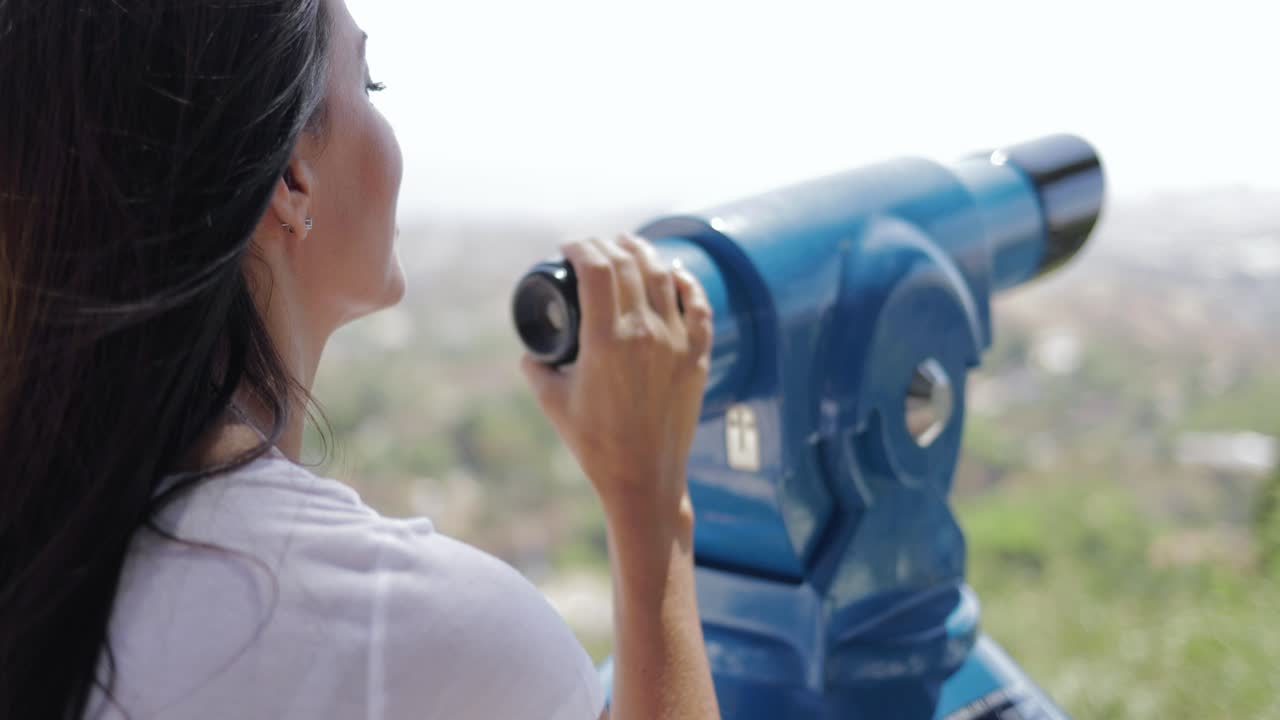 도시 관점에서 망원경을 사용하는 여자