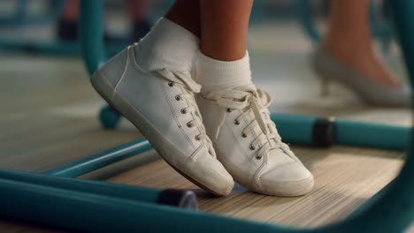 Student-Sitzt-Am-Schreibtisch-Im-Klassenzimmer.-Mädchen-Trägt-Weiße-Turnschuhe-Mit-Socken