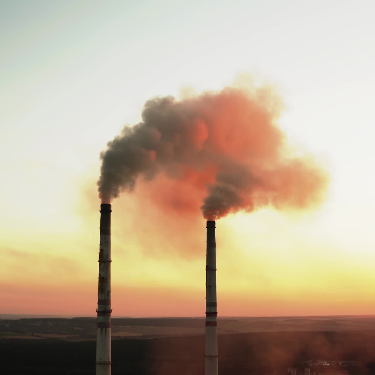 Plant pipes pollute atmosphere. Aerial drone view of high smoke stack
