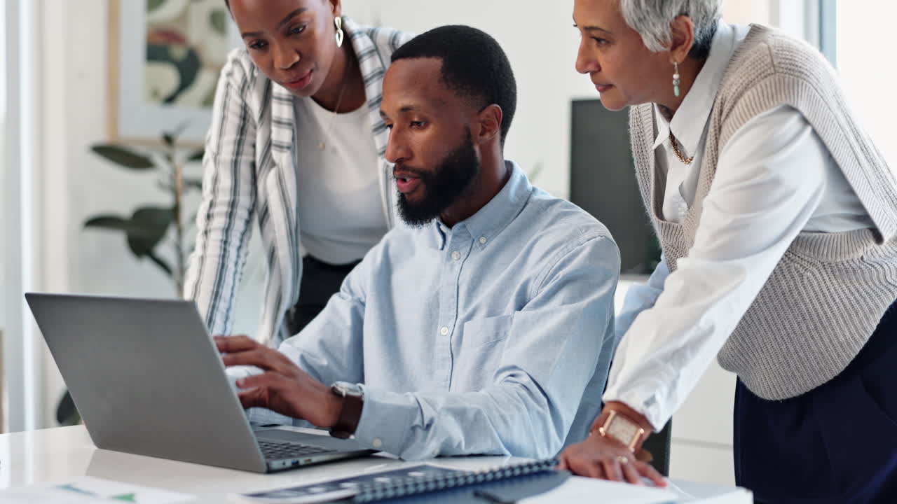 Team collaborating on a laptop in the office