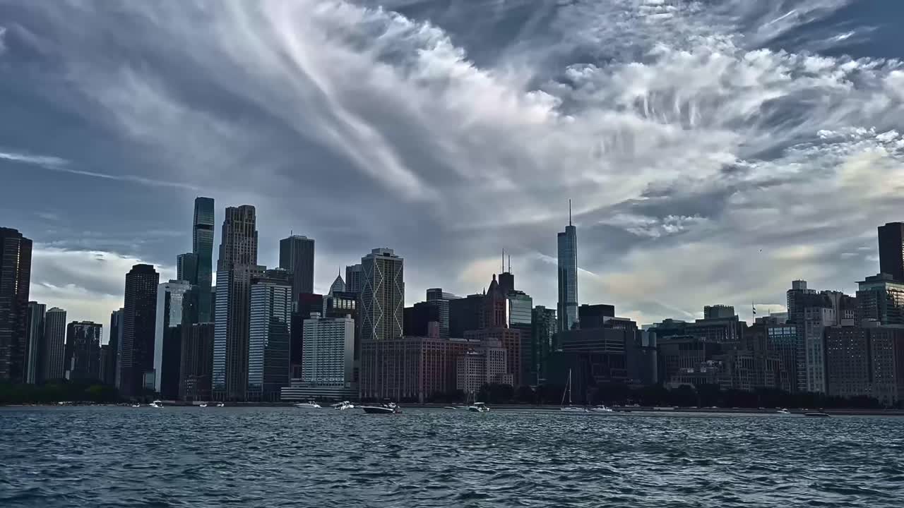 A breathtaking view of Chicago’s skyline captured from Lake Michigan with rippling waves and moody clouds overhead during dusk.