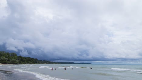 dark clouds passing over lake with family in water timelapse