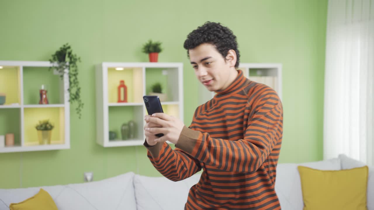 소년은 집에서 혼자 춤을 추고, 음악을 듣고, 소셜 미디어를 사용하고 있습니다.