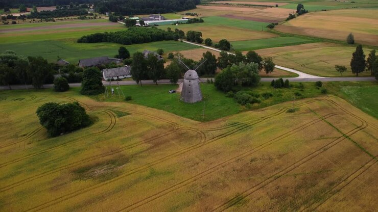 ripresa aerea di un vecchio mulino a vento nel campo vicino alla strada, zoom indietro