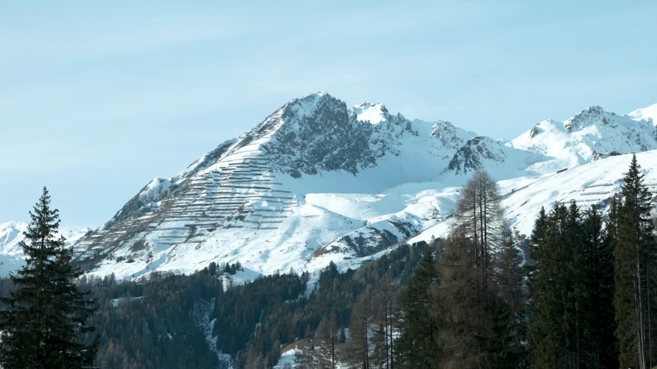 Vista dall'auto di cime montuose innevate in una giornata di sole a Davos, Svizzera