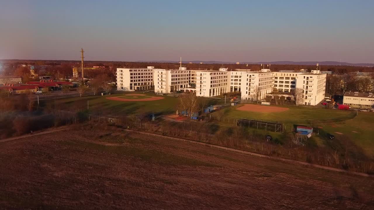 Aerial View of a Large White Building with Baseball Fields