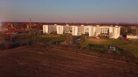 aerial view of a large white building with baseball fields