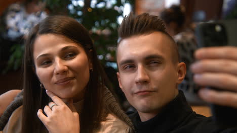 young couple taking selfie in a cafe