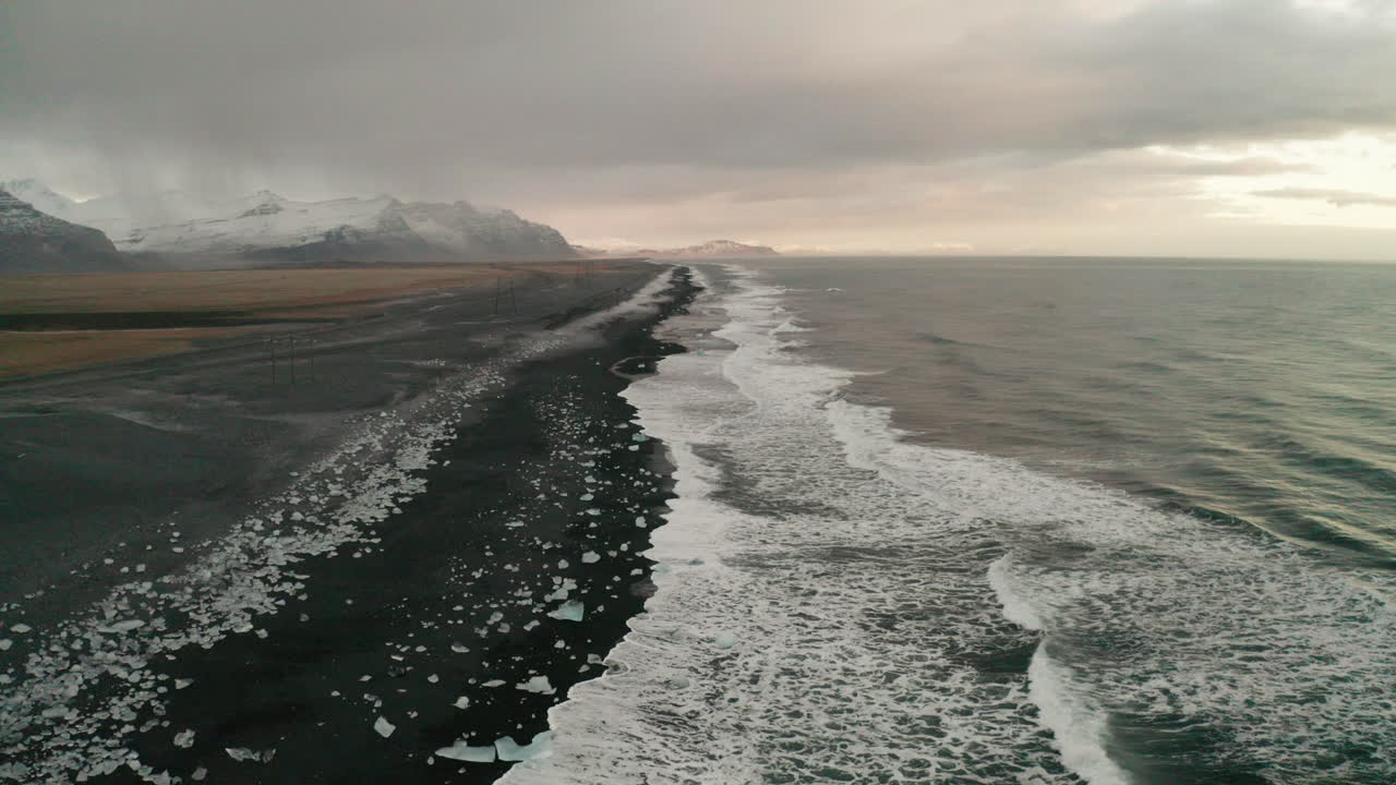 hermosa y tranquila playa de diamantes helados del sur de islandia al atardecer - un dron aéreo bajo disparó sobre breiðamerkursandur