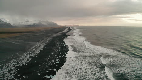 beautiful calm icy diamond beach of south iceland at sunset - low aerial drone shot over breiðamerkursandur