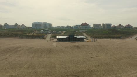 Aerial-view-of-an-empty-beach-club-at-the-beach-of-Noordwijk-during-the-morning