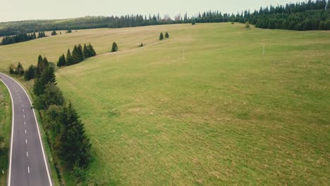 Forward-drone-shot-over-a-road-next-to-a-valley