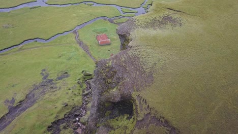 Video-Aéreo-Sobrevolando-Una-Montaña-Que-Revela-Un-Granero-Y-Un-Río