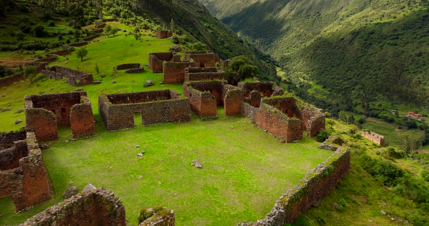 Starożytne stanowisko archeologiczne Inków Pumamarka na bujnym zielonym zboczu wzgórza w Świętej Dolinie w Peru. Ujęcia z drona cofającego się.