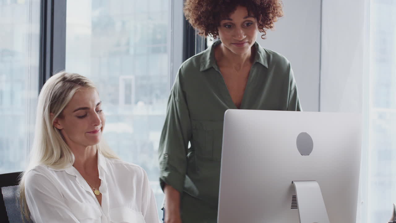 mujer negra milenaria está hablando con una colega en su escritorio luego se aleja, tiro de inclinación