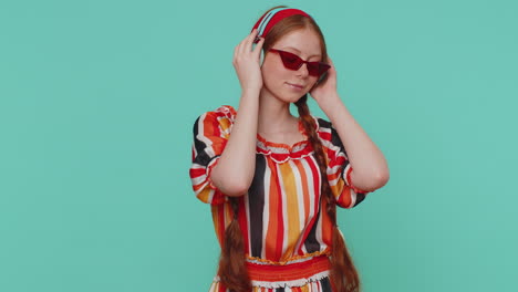 una joven pelirroja alegre escuchando música a través de auriculares y bailando en una discoteca divirtiéndose