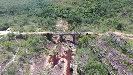 Aerial-drone-shot-of-hard-rocky-and-brown-river-in-the-middle-of-dry-hills