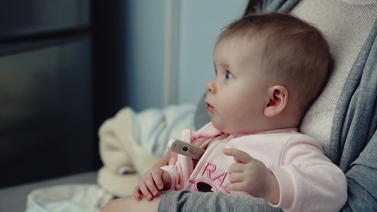 팔 에 온도계 를 들고 있는 아이