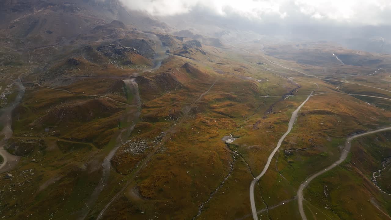 Push in aerial establishing shot of an amazing misty landscape in Cervinia, Italy, Aosta Valley, Valle d’Aosta, showing atmospheric alpine scenery