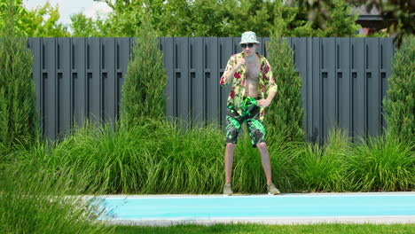 hombre bailando junto a la piscina en un traje tropical
