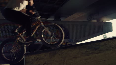 Extreme-bmx-rider-jumping-with-bicycle-at-skate-park.-Close-up-bike-wheels.