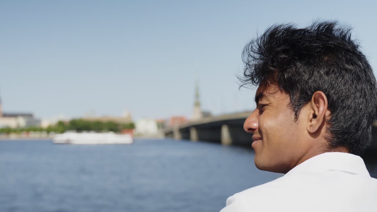 도시 시내와 강의 전망을 즐기는 행복한 인도 학생 기업가