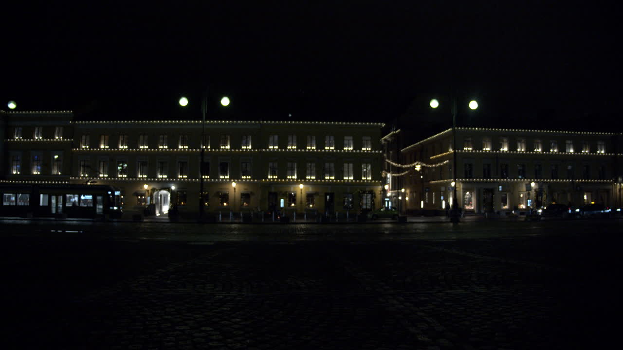 핀란드 헬싱키에서 크리스마스 시간 동안 지나가는 지하철 열차와 도로를 건너는 사람들을 보여주는 밤에 실루엣 샷