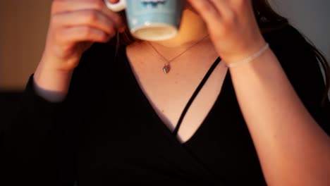 Woman-with-big-brown-eyes-drinking-coffee-at-sunset-at-home