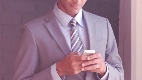 smiling businessman typing on his smartphone