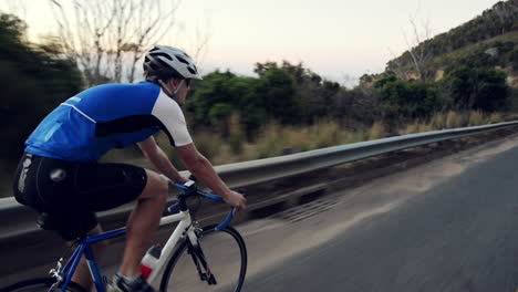 man cycling on coastal road