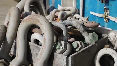 heavy navy stainless steel chain and its parts neatly arranged in a wooden box on the dock, ready for use