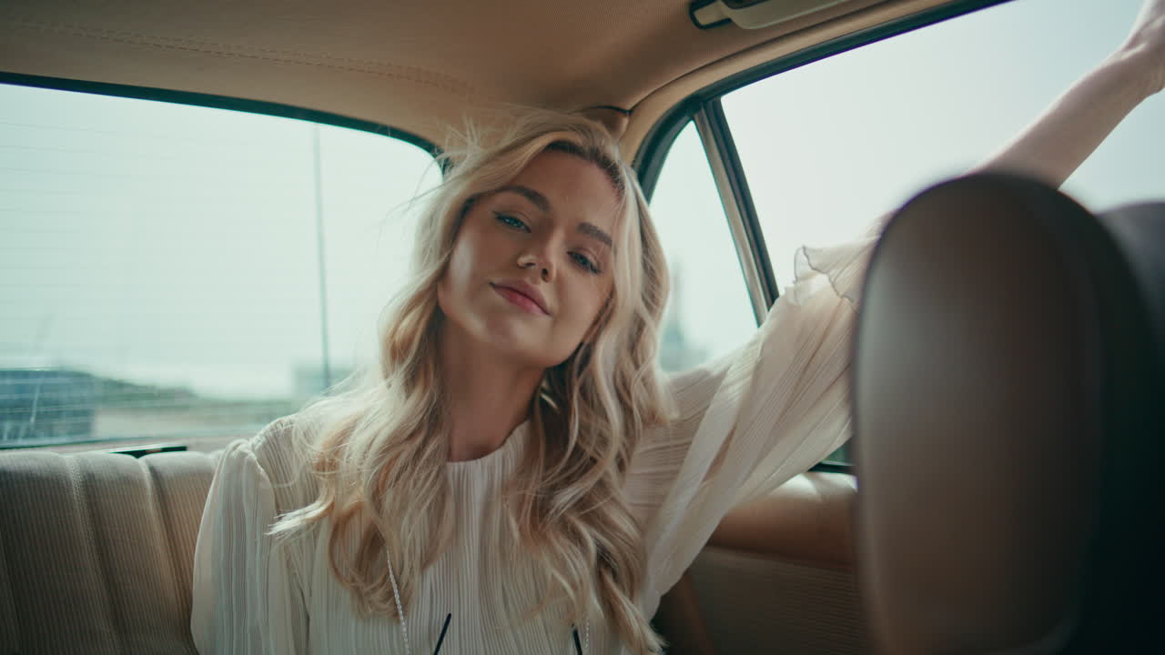 무관심한 여자는 열린 창문에서 손을 잡고 레트로 자동차를 타고 즐기고 있습니다.