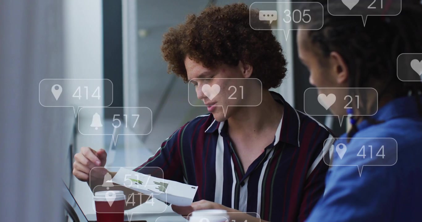 Man pointing at report, activating social overlays over laptop while analyzing marketing charts