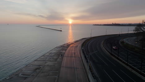 Luftaufnahme,-Die-Einem-Mann-Folgt,-Der-Auf-Dem-Seeuferweg-Läuft,-Sonnenaufgang-In-Chicago,-USA