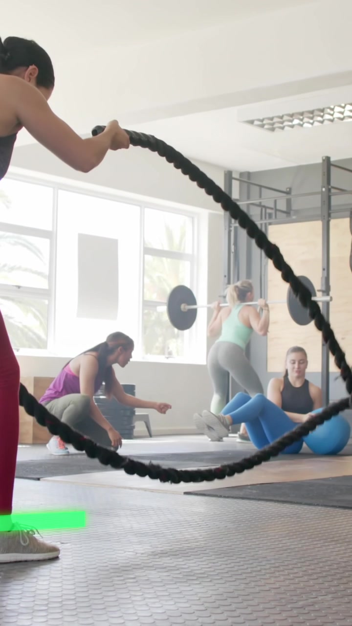 Animación de gráfico procesando datos sobre una mujer caucásica haciendo entrenamiento cruzado con cuerdas de batalla en el gimnasio