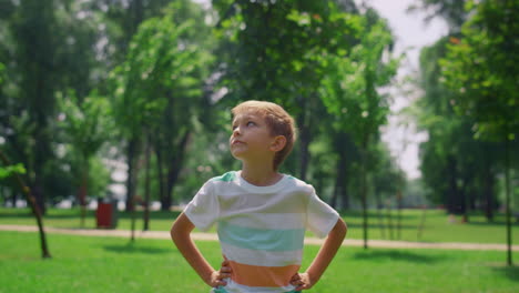 Portrait-of-boy-looking-around-lawn-close-up.-Cheerful-child-standing-on-meadow.